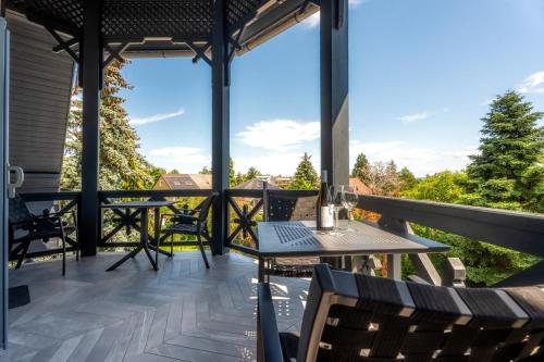 a patio with a table and chairs on a balcony at Villa Viktória in Balatonfüred