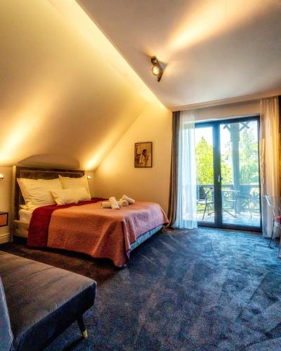 a bedroom with a bed and a large window at Villa Viktória in Balatonfüred