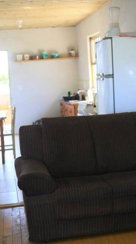 a living room with a couch and a refrigerator at Casa de praia - Descanse e tenha uma experiencia relaxante a poucos metros da praia in Arroio do Silva