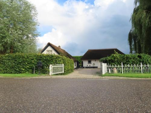 a house with a white fence and a gate at B&B de Pinguin in Bergentheim