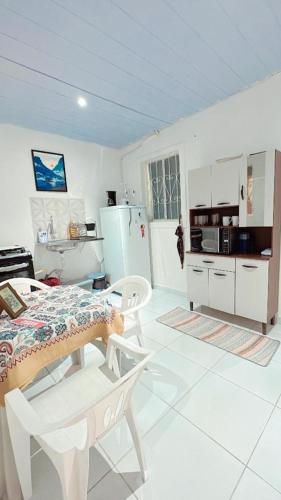 a white kitchen with a table and chairs in it at Napolitan House in Manaus