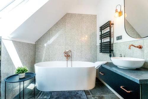 a bathroom with a large tub and a sink at Villa Viktória in Balatonfüred