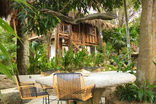 a table and chairs in front of a house at Hierba Buena Eco Hostel in El Zaino