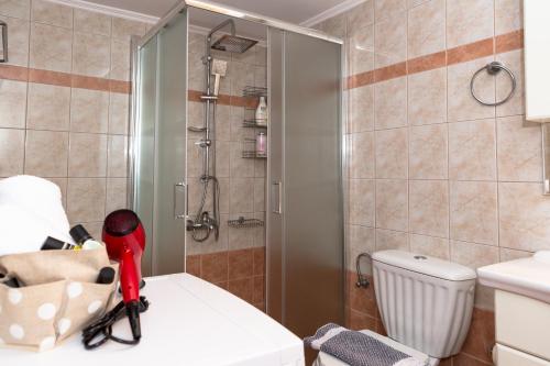 a bathroom with a shower and a red vacuum cleaner at Aroma of the Sea in Kissamos