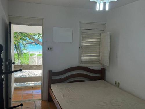 a bedroom with a bed and a view of the ocean at Casa Pê na Areia e Vista ao Mar em São José in São José da Coroa Grande