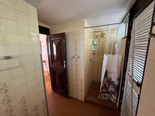 a bathroom with a wooden door and a hallway at Casa Pê na Areia e Vista ao Mar em São José in São José da Coroa Grande