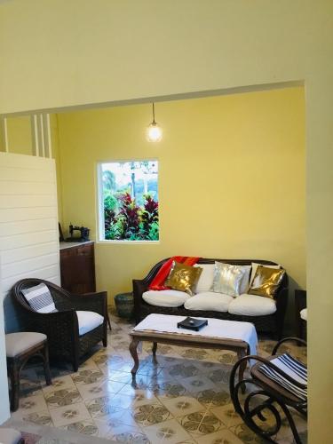 a living room with a couch and a table at Villa Coquelicot in Rivière-Pilote
