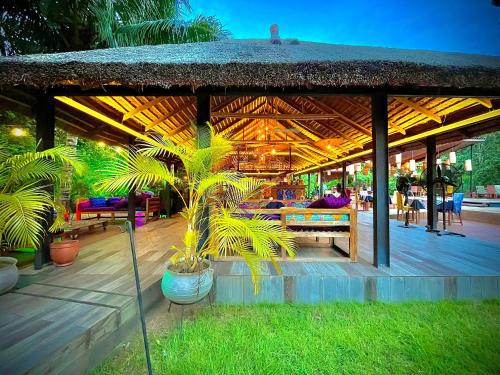a wooden deck with a pavilion with a palm tree at Le Patio in Lomé
