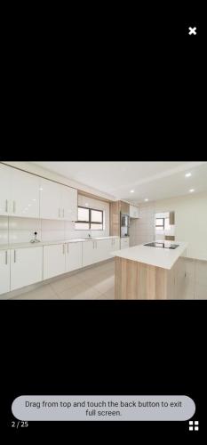 a large kitchen with white cabinets and a counter at KWT property in Soweto