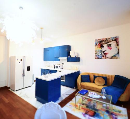 un salon avec un canapé et une cuisine dans l'établissement LE PATIO LAFAYETTE Appartement de Standing coeur de ville, à Vichy