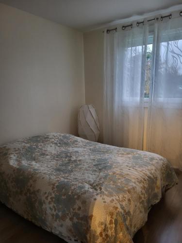 a bed in a bedroom with a window at Location Jeux Olympiques Paris 2024 in Élancourt