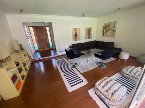 a living room with a couch and a table and chairs at Casa Amoblada en chicureo in Chicureo Abajo