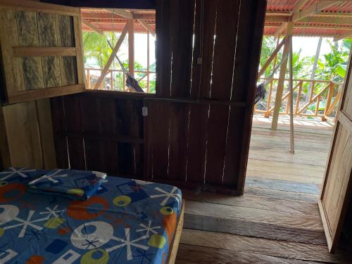 una camera con un letto e una porta aperta di Hostal San Mabel Herping - Playa Cuevita a El Valle