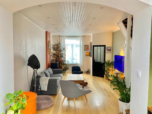 een woonkamer met een bank en een tafel bij Maison LILLE 6 personnes avec Jardin in Lille