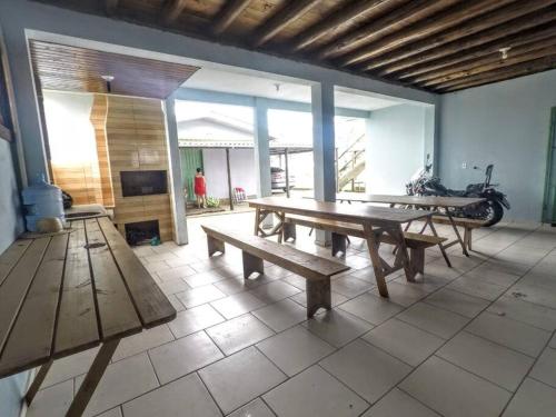 una habitación con mesas de madera y una motocicleta. en Casa na Beira Mar - Relaxe sentindo a brisa do Mar a poucos metros do oceano, en Arroio do Silva