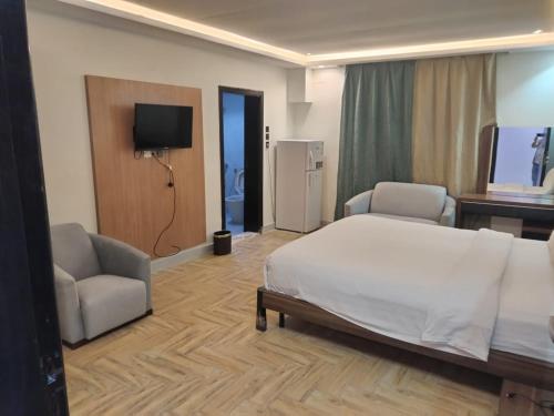 - une chambre avec un lit, deux chaises et une télévision dans l'établissement سما ستار للشهري والسنوي, à Djeddah