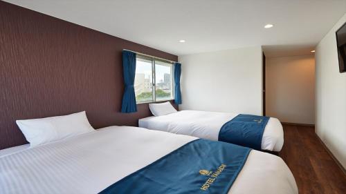 1 dormitorio con 2 camas y ventana en Hotel Yamaichi - Vacation STAY 88168v, en Naha