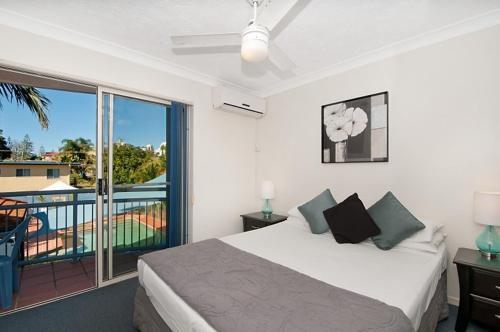 1 dormitorio con 1 cama grande y balcón en Santana Resort Surfers Paradise, en Gold Coast