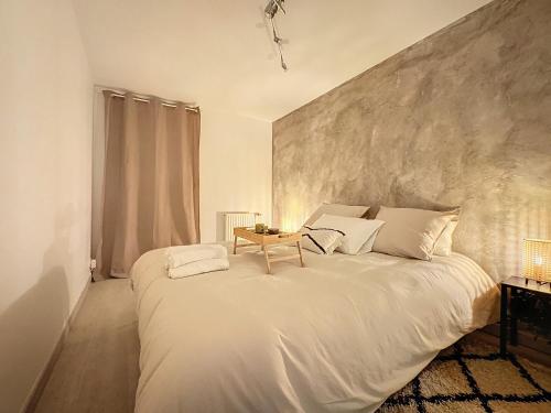 - une chambre avec un grand lit blanc et une table dans l'établissement Chaleureux et spacieux - Paris - Stade de France, à Saint-Denis