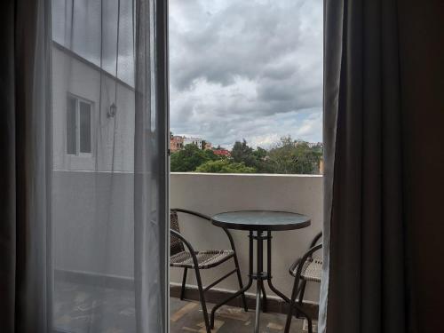 a balcony with a table and chairs and a window at Hotel Jardín del Cantador in Guanajuato