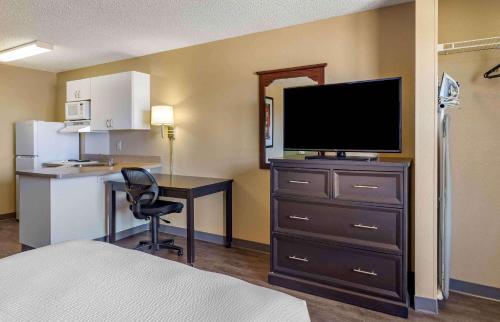 Cette chambre comprend un lit et un bureau avec une télévision. dans l'établissement Extended Stay America Suites - Houston - Westchase - Richmond, à Houston