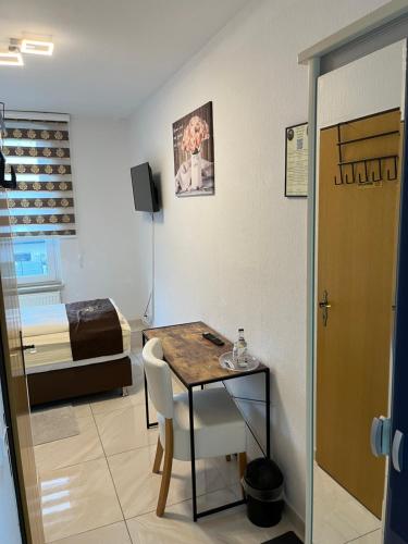 a room with a table and a bed and a bedroom at Hotel Royal in Leopoldshöhe