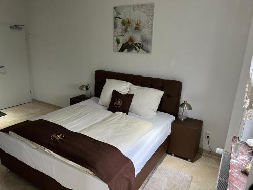 a bedroom with a large bed with white sheets at Hotel Royal in Leopoldshöhe