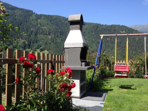 a stone fireplace in a yard with a swing at Gschlössle Ferienwohnungen in Jerzens
