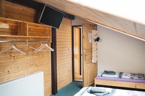 Habitación con paredes de madera y TV en la pared. en Gasthaus Kitzloch en Taxenbach