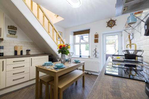 a kitchen with a table and a staircase at The Bay Cottage Hot Tub & Sauna Morecambe Bay in Morecambe