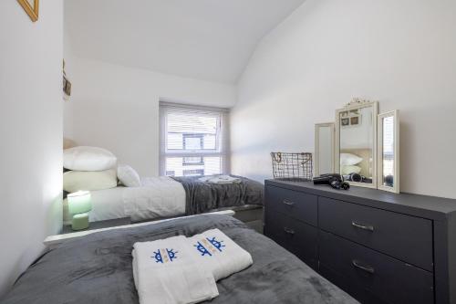 una camera con due letti, un comò e uno specchio di The Bay Cottage Hot Tub & Sauna Morecambe Bay a Morecambe