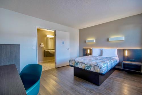 a bedroom with a bed and a table and a room at Motel 6 Santa Fe in Santa Fe