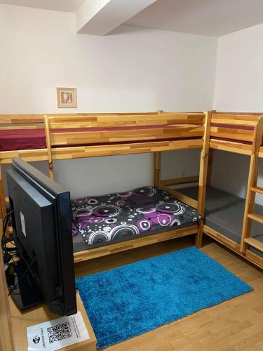 a room with two bunk beds and a computer monitor at Apartmán Diana in Oščadnica