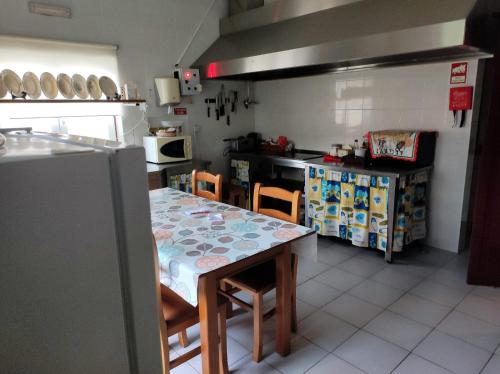 a kitchen with a table and chairs and a counter at Casa do Lago in Vila de Rei