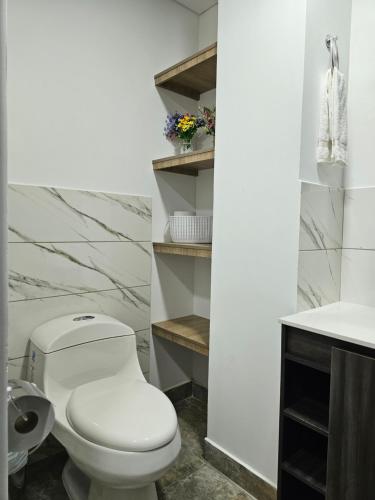 Baño blanco con aseo y lavamanos en Apartamento en Filandia, en Filandia
