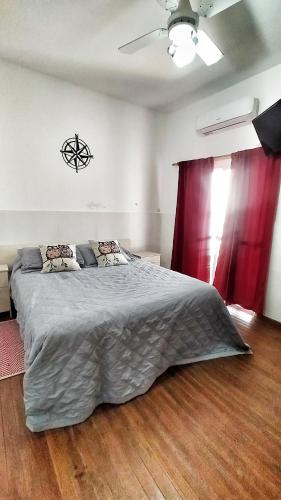 Schlafzimmer mit einem großen Bett und roten Vorhängen in der Unterkunft Lavalle III in Venado Tuerto