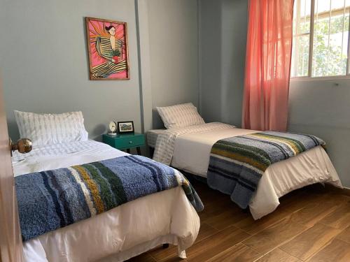 康塞普西翁德阿塔科的住宿－El Hogar del Torogoz，一间卧室设有两张床和窗户。