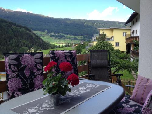 a table with a vase of flowers on a balcony at Gschlössle Ferienwohnungen in Jerzens