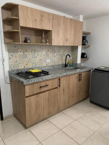 a kitchen with wooden cabinets and a stove top oven at Bellísimos apartamentos céntricos en La Mesa in La Mesa