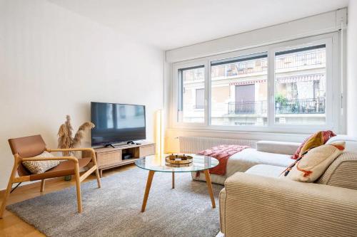 uma sala de estar com um sofá e uma televisão em Stylish Lakeside Home by the Jet d'Eau em Genebra