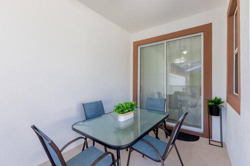 a dining room with a glass table and chairs at Family 4BR w Private Pool near Disney Parks in Kissimmee
