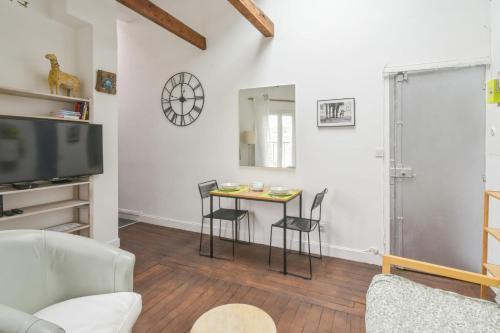 un salon avec une table et des chaises dans l'établissement Appartement Surcouf - Welkeys, à Paris