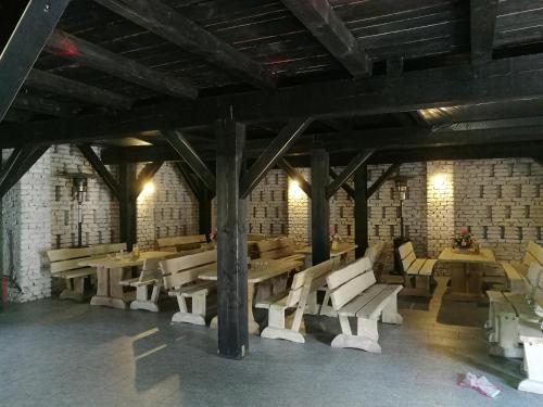 a room with wooden tables and chairs in a building at Jarzębinowy Agroturystyka in Braniewo