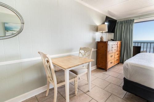 1 dormitorio con mesa, sillas y 1 cama en Majestic Seascape 6th Flr Oceanfront King Room, en Pawleys Island