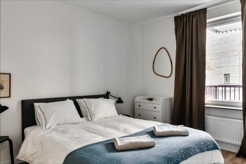 a bedroom with a bed with two towels on it at Stylish Urban Home in Stockholm in Stockholm