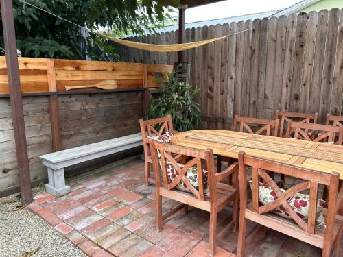 a patio with a wooden table and chairs and a bench at Eastside Costa Mesa house in Costa Mesa