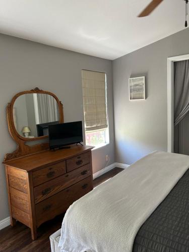 a bedroom with a bed and a dresser with a mirror at Eastside Costa Mesa house in Costa Mesa