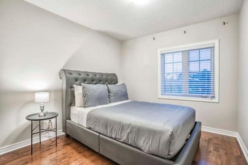 1 dormitorio con cama y ventana en Designer 4BR Executive Townhome w/Parking en Mississauga