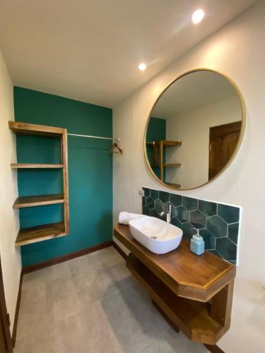 a bathroom with a sink and a mirror at Oasis by Franklin Hotel Boutique in Fortuna