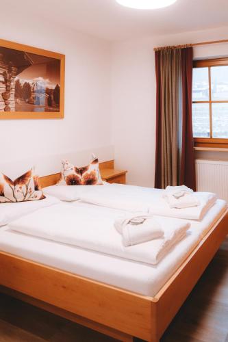 a bedroom with a large bed with white sheets at Anewandterhof in Brunico